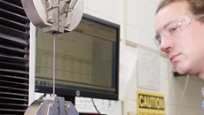 A scientist observes a test of the elongation of a conduit sample 230p